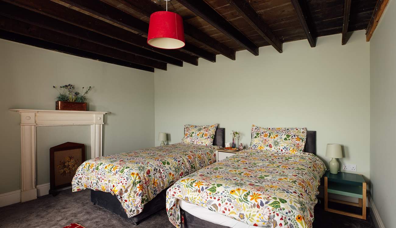 Sea facing twin room on the ground floor with exposed beams and traditional decorative fireplace. 