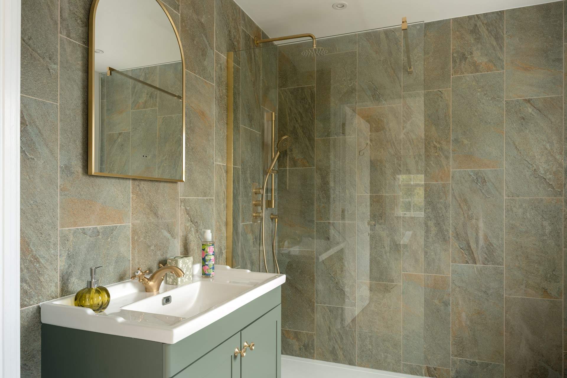 Tiled from floor to ceiling, the en suite is both practical and elegant.