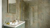 Tiled from floor to ceiling, the en suite is both practical and elegant.