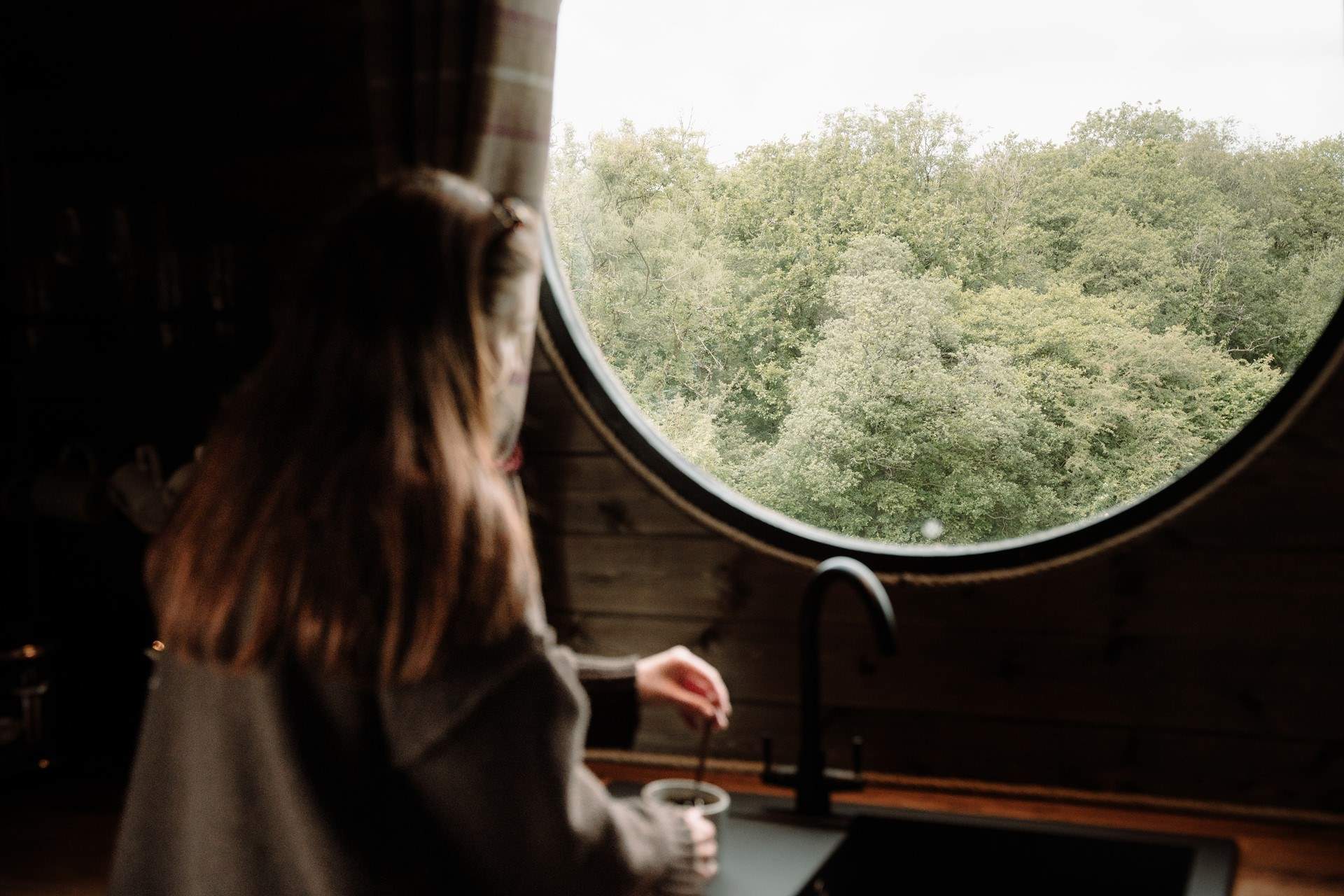 Morning coffees are framed by trees and stillness through the large round window.