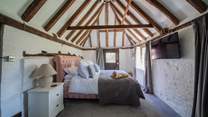 The ground floor bedroom has a beautiful pitched roof, beams and a door leading to the cottage garden.