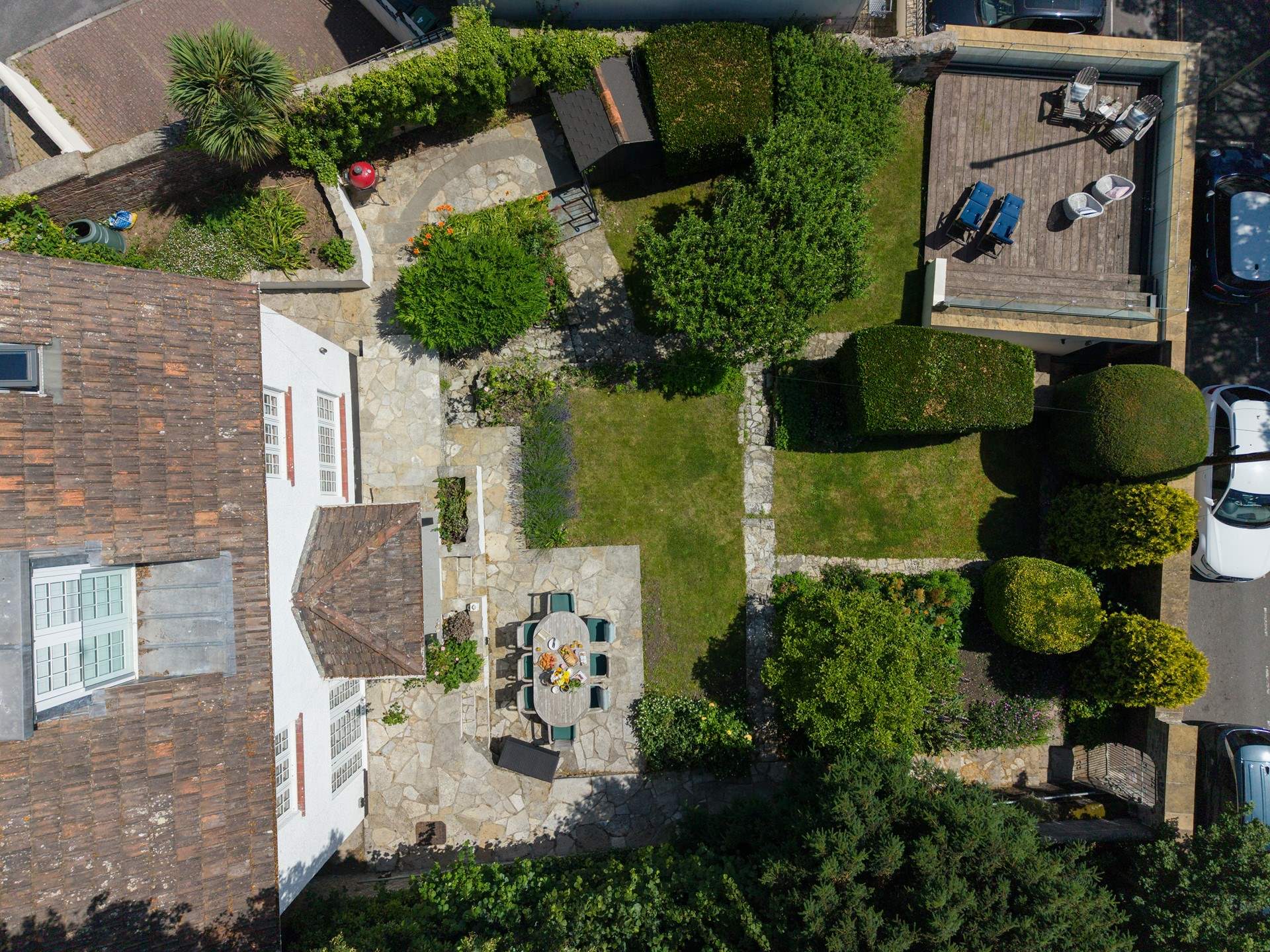The enclosed grounds of Langmoor House are just as impressive as the interiors. Seen here from above you have a dining-area, lawns, a barbecue-area, shady patio and a sun deck with captivating sea views.