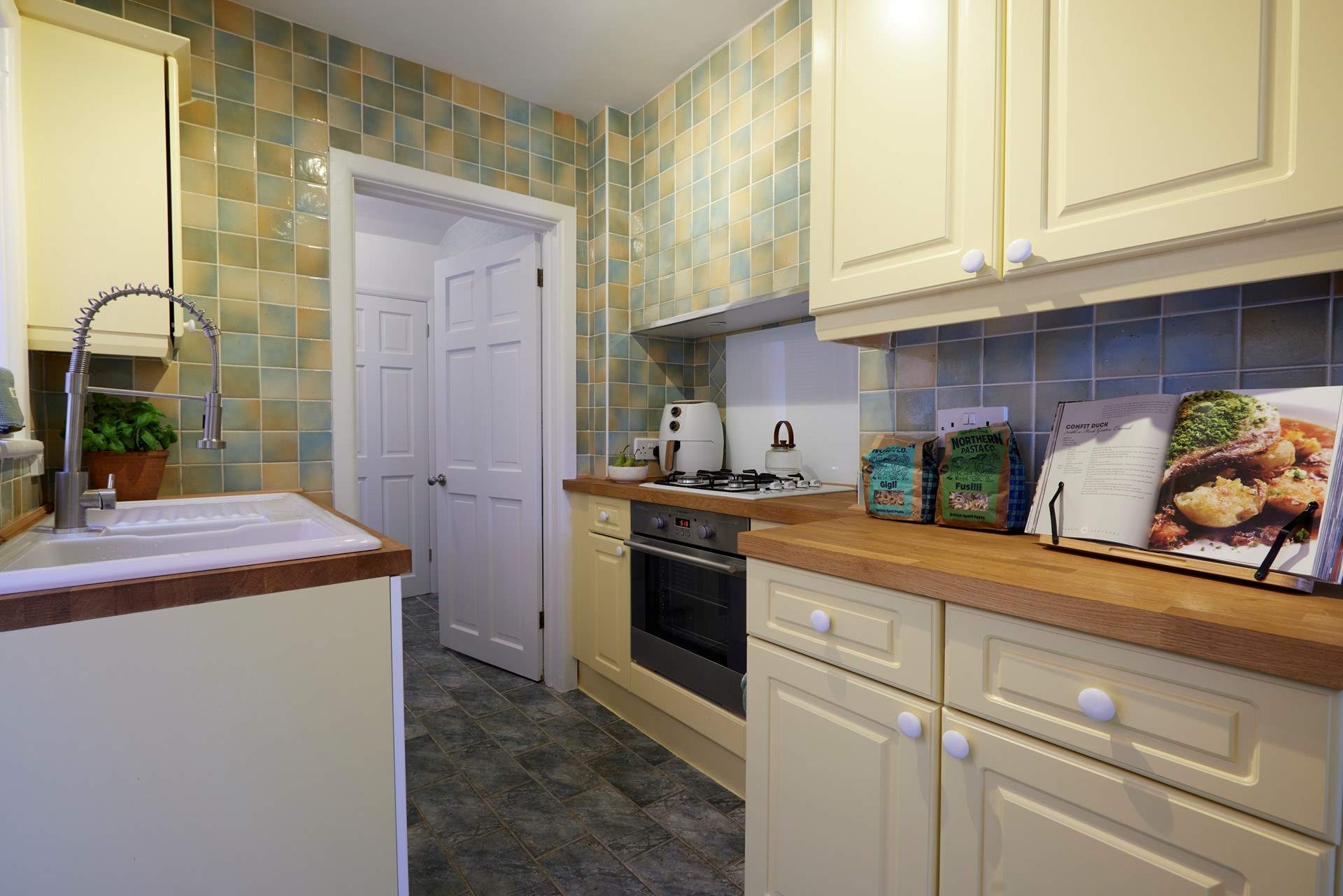 The galley kitchen is very functional and has everything you would expect from such a lovely home. It also has side access out to the garden.