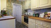 The galley kitchen is very functional and has everything you would expect from such a lovely home. It also has side access out to the garden.