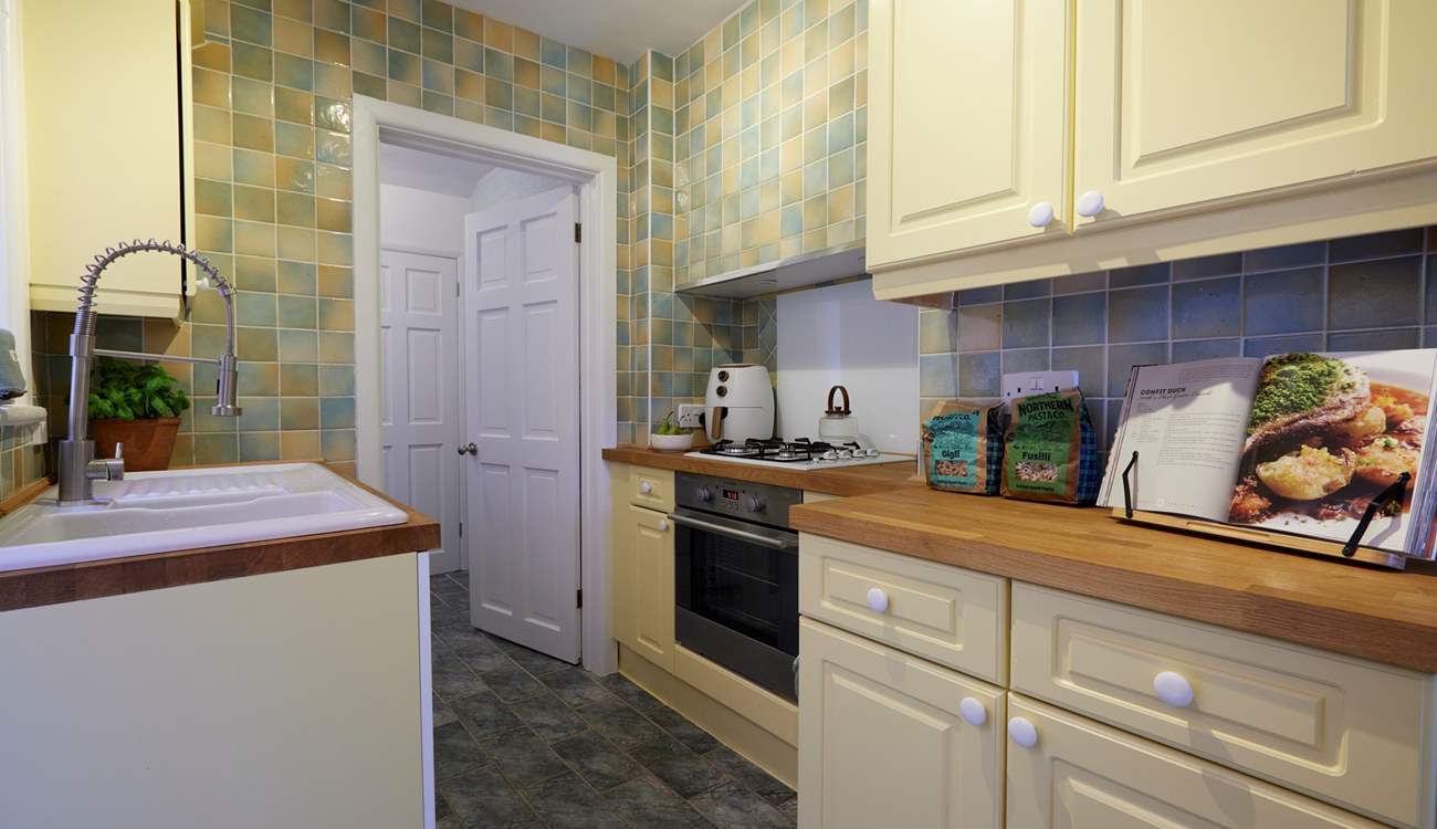 The galley kitchen is very functional and has everything you would expect from such a lovely home. It also has side access out to the garden.