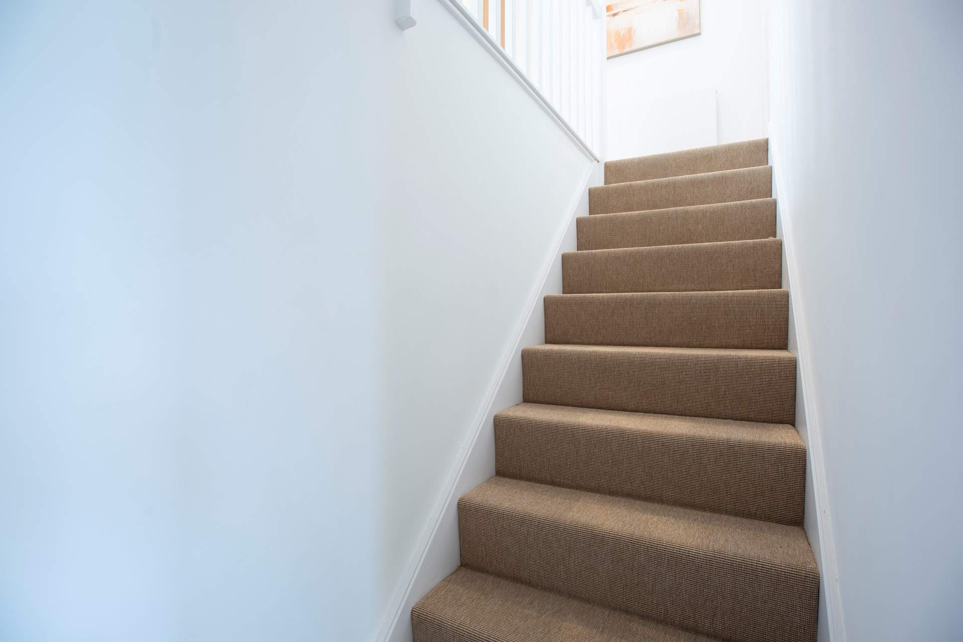 The stairs leading from the downstairs bedrooms to the upstairs living area.