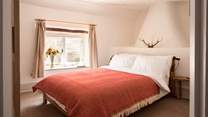 The main bedroom is beautiful and spacious with a storage/hanging area and inviting double bed.