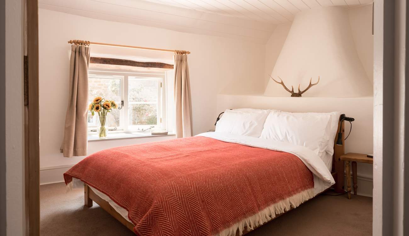 The main bedroom is beautiful and spacious with a storage/hanging area and inviting double bed.