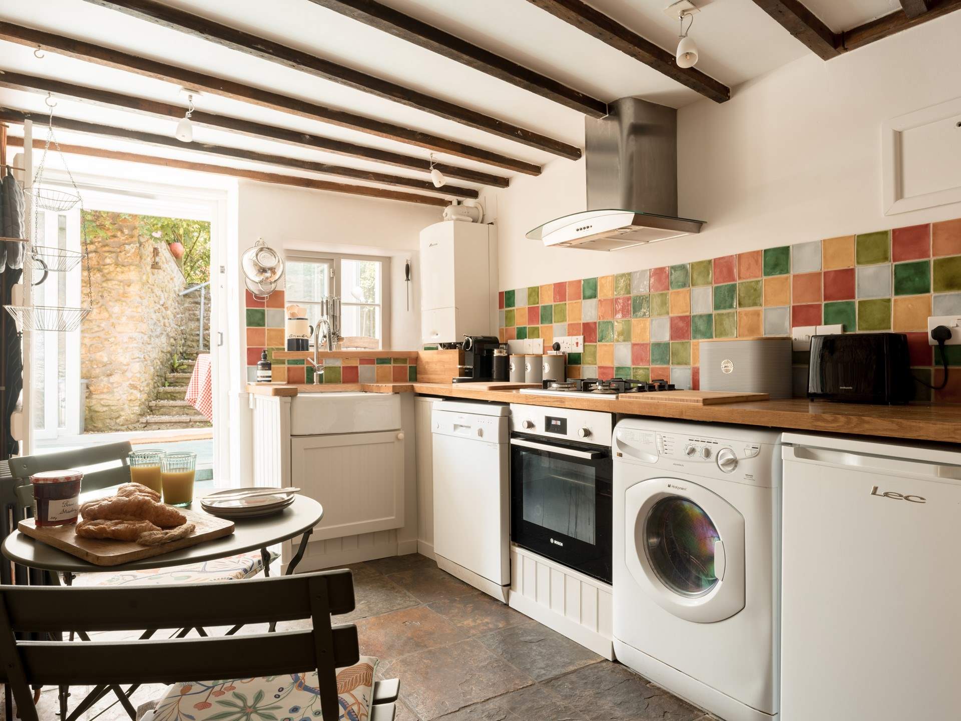 The simple cottage kitchen has everything you would expect from a well thought through space, and has a wonderful flow through into the sun-room and garden beyond...