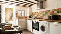The simple cottage kitchen has everything you would expect from a well thought through space, and has a wonderful flow through into the sun-room and garden beyond...