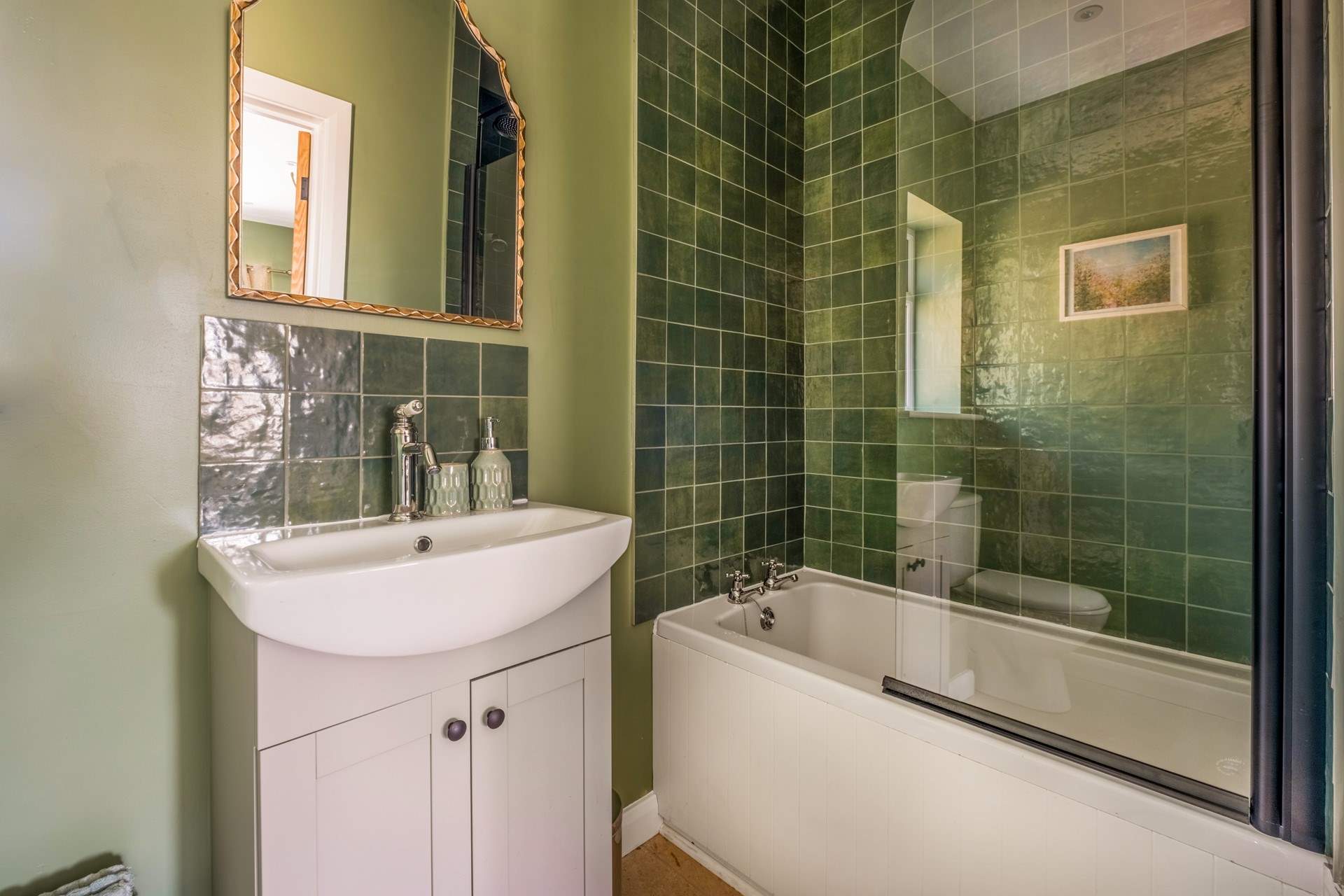 The en suite bathroom has a bath with shower over.