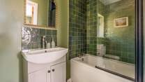 The en suite bathroom has a bath with shower over.