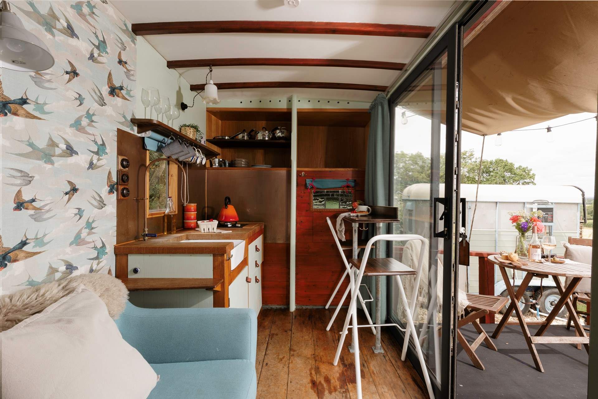 The light-filled living area where warm wooden tones blend with the natural world outside. 