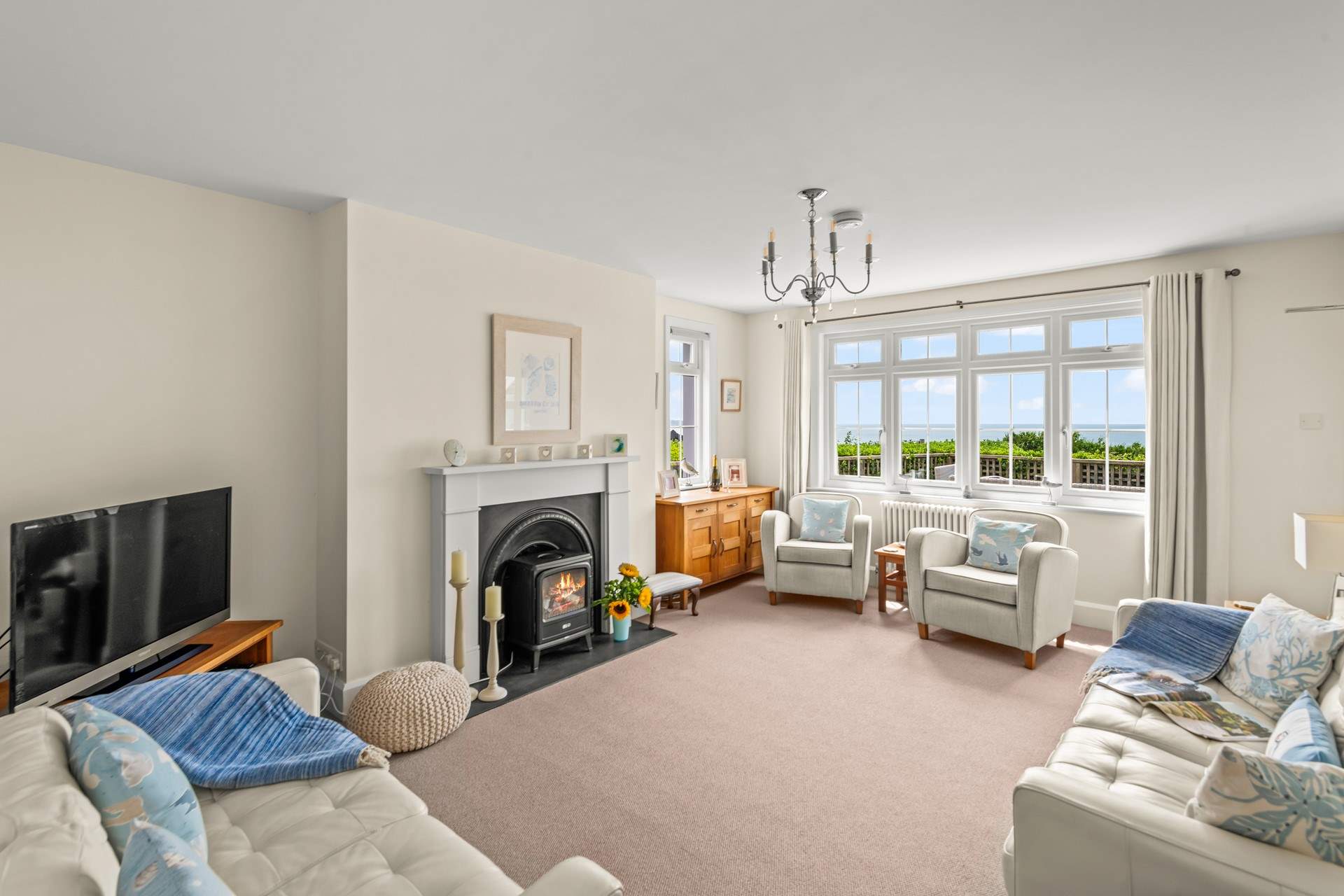 The sitting-room offers incredible sea views and a wood-burner effect electric stove to set the super cosy setting.