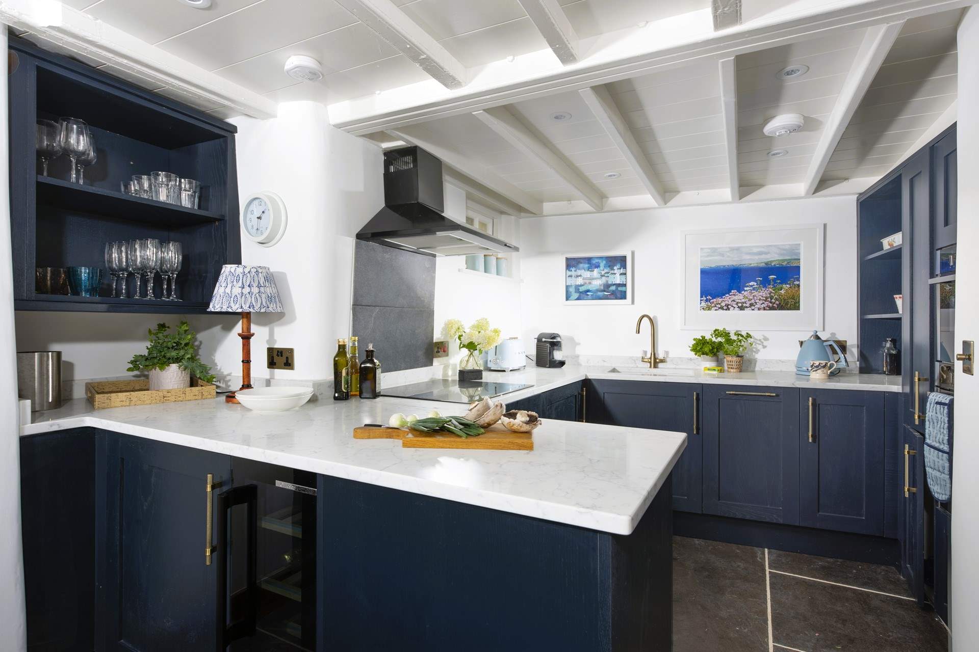 The exposed beams and slate floor add to the overall charm and character of the cottage.