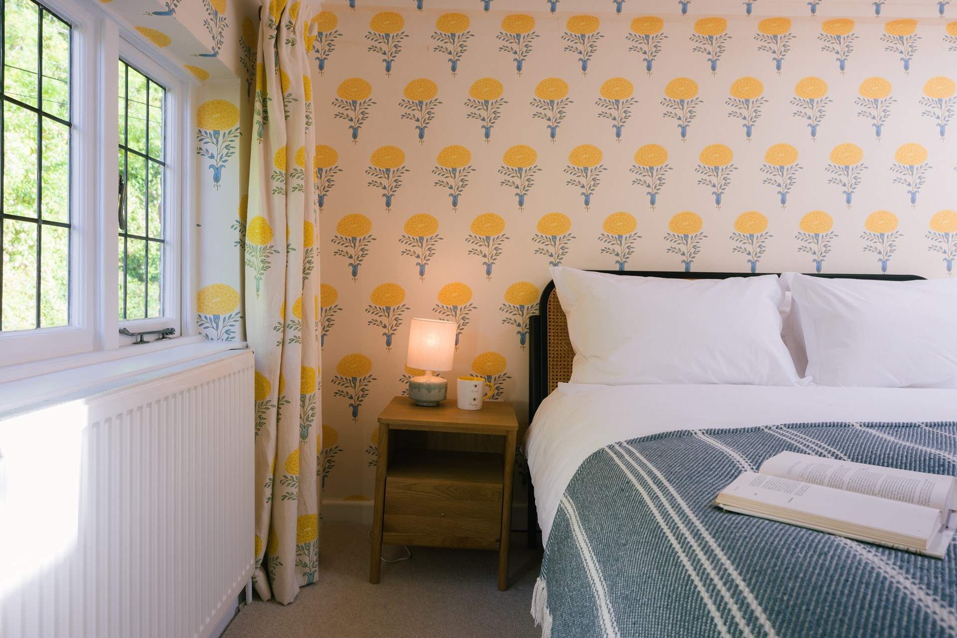 Adorned with sunflower wallpaper this wonderfully uplifting room has lots of natural light.