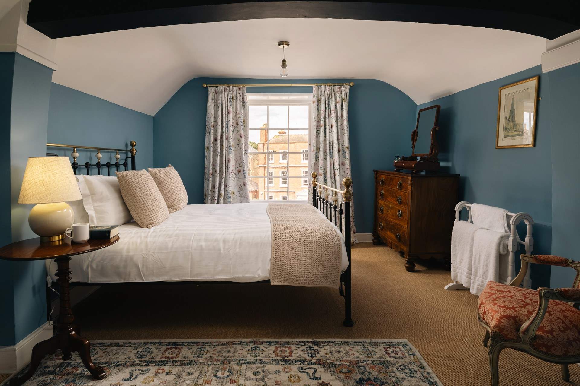 The second floor bedroom has an impressive bed and antique furniture.