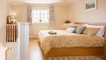 The pretty bedroom with calming tones and a king-size bed.
