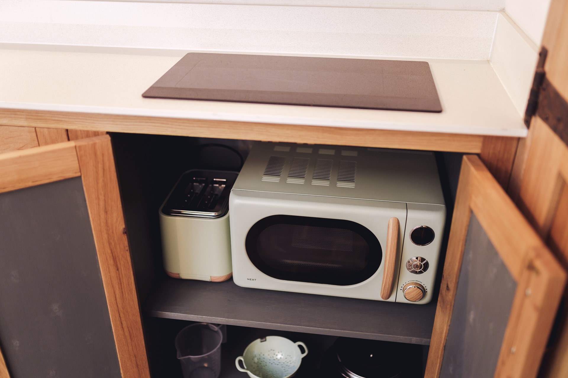 The microwave and toaster tuck away in the cabinets to ensure you have plenty of worktop space. 