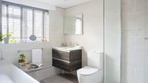 The family bathroom is spacious and has a shower cubicle and a bath.