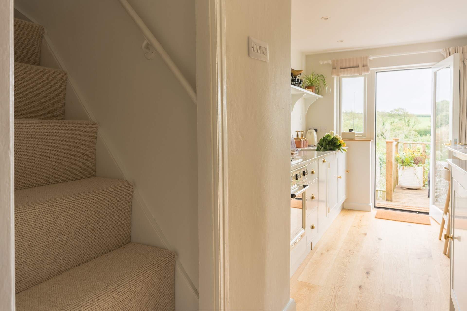 After stepping up from the kitchen, use the handrail to climb the steep original stairs to find both bedrooms.