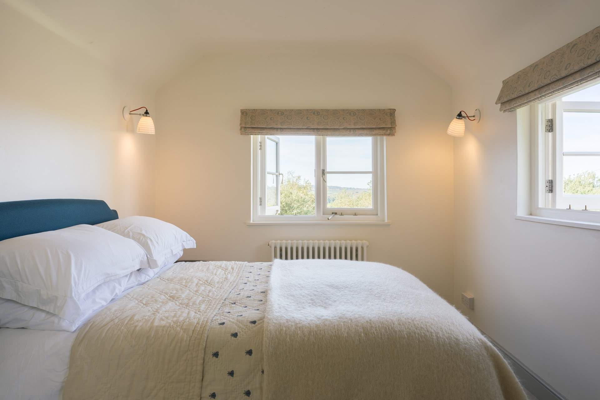 Bedroom 2 floods with light and has views of rolling green fields.