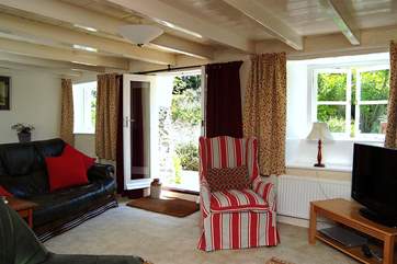 The comfortable sitting-room has French doors leading out to the front garden.