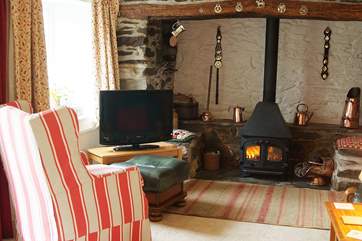 A welcoming wood-burner nestles in the huge inglenook fireplace.