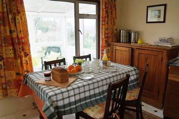 The kitchen table has views through the conservatory to the garden...
