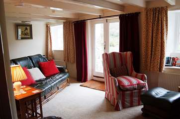 The comfortable sitting-room has French doors leading out to the front garden.