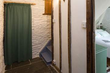 Steep wooden stairs down to the pretty ground floor bedroom.