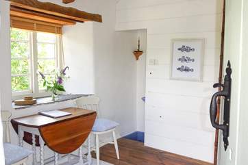 The dining-area leads down towards the bedroom.