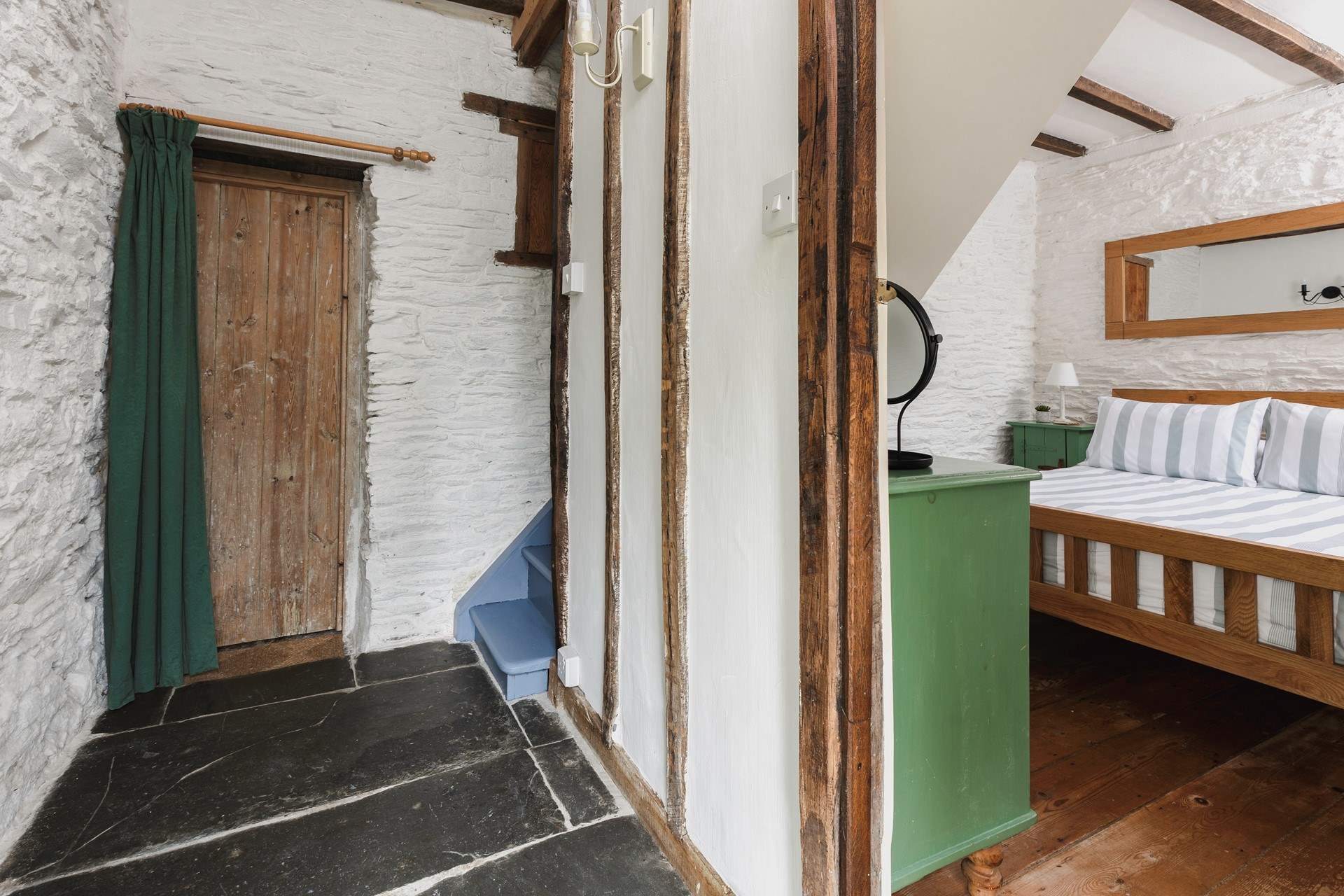 The pretty bedroom is on the ground floor and the stairs lead to the living space on the first floor.