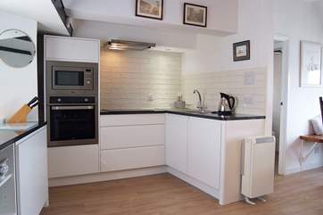 The attractive kitchen is very well-equipped with a built-in microwave, oven and hob.