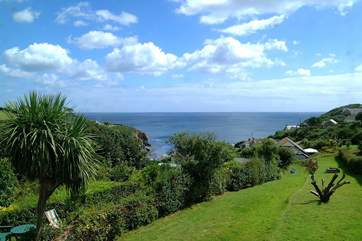 The stunning view from two of the bedrooms across the cottage garden to the cove and beyond.