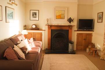 The Victorian cast-iron fireplace adds character to the cosy sitting-room as well as additional warmth on those cooler evenings.