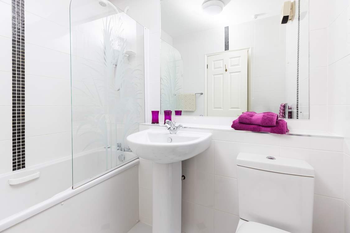 The bathroom has a bath with fitted shower over.