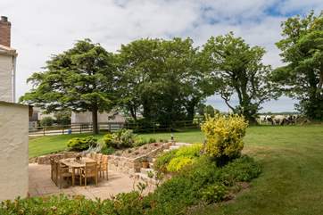 The large garden wraps around the rear and front of the cottage.
