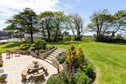 The large garden and terrace wraps around the rear and front of the cottage at Lower Trenower. 