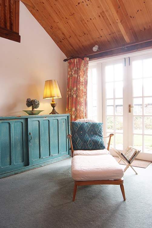 This relaxing chair by the French doors, where the light floods in, provides the perfect place for reading.