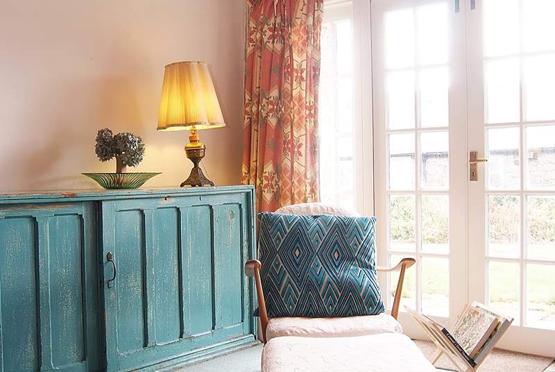 This relaxing chair by the French doors, where the light floods in, provides the perfect place for reading.