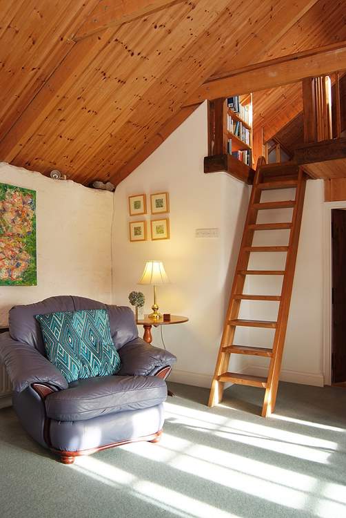 A custom-built ladder leads up to a snug reading-area in the gallery above the sitting-room (please take care with young children).