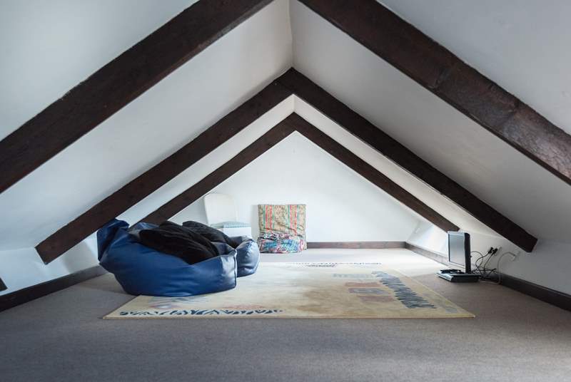 The galleried den up under the eaves is accessed via a wooden ladder from the sitting-room, the beanbags are great for children to lounge on and watch television.