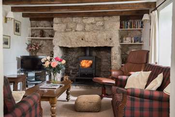 The cosy front sitting-room also features a welcoming wood-burner.
