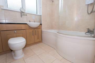 The bathroom with an electric over head shower.