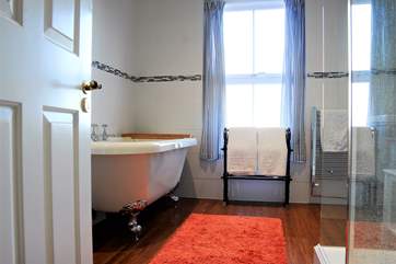 The lovely big family bathroom has a claw-foot bath and a big walk-in shower cubicle.