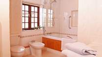 There is a really large family bathroom with bath and shower.