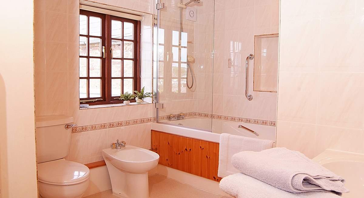 There is a really large family bathroom with bath and shower.