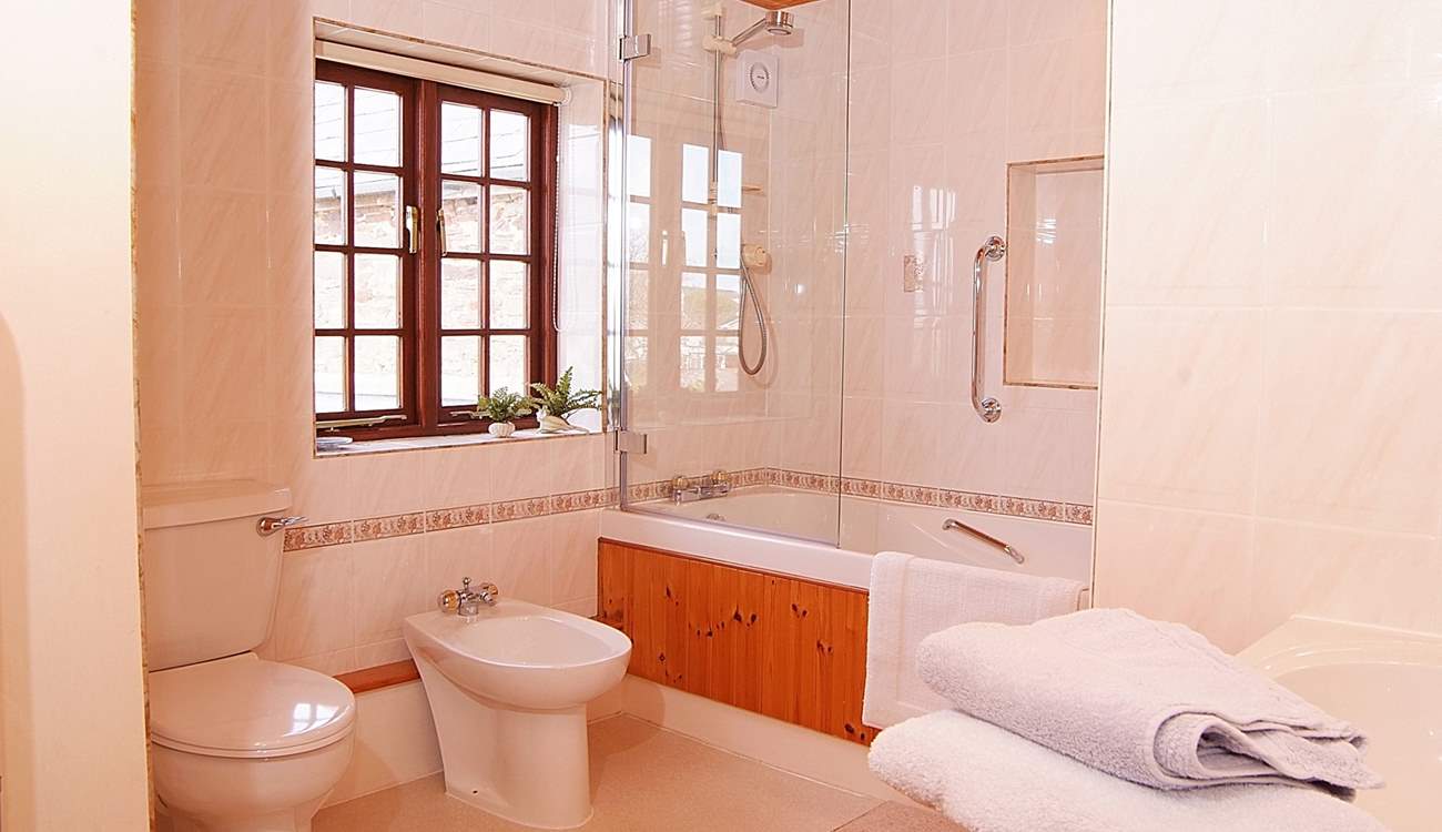 There is a really large family bathroom with bath and shower.
