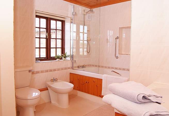 There is a really large family bathroom with bath and shower.
